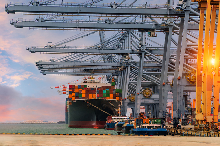 Ein Containerschiff setzt am Hafen an.