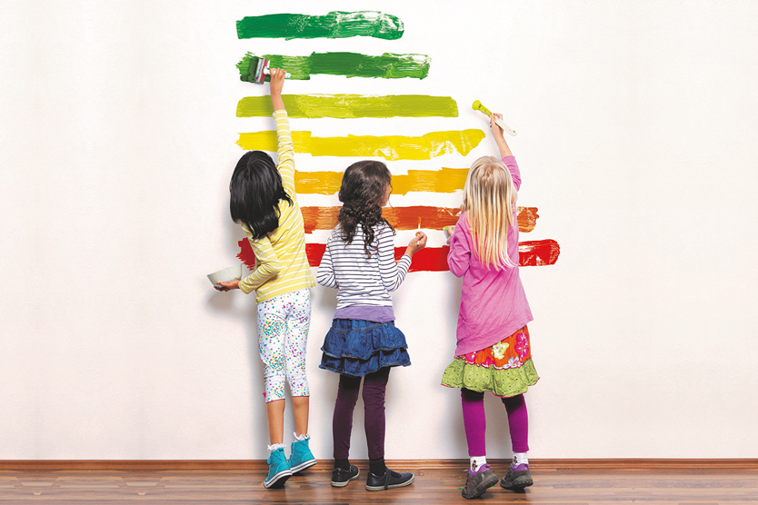 Kinder malen Energieeffizienzlabel symbolisiert Energieeffizienz von Heizgeräten; Quelle: gettyimages/Severin Schweiger
