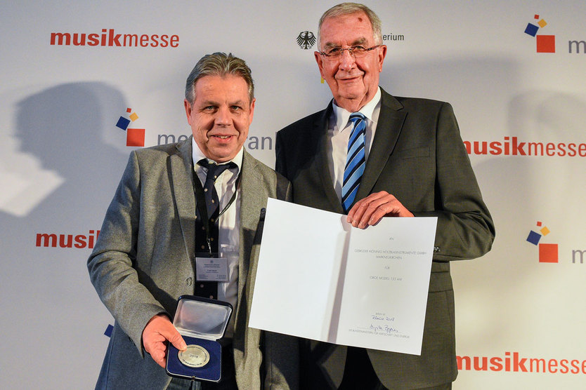 Geschäftsführer Frank Meyer nahm stellvertretend für die Preisträgerfirma "Gebrüder Mönnig" aus Markneukirchen (links) den Preis von Ernst Burgbacher (rechts) entgegen. 