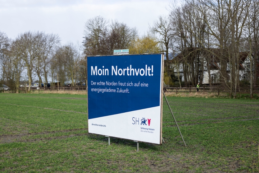 Plakat auf Wiese mit Aufschrift: Moin Northvolt! Der echte Norden freut sich auf eine energiegeladene Zukunft.