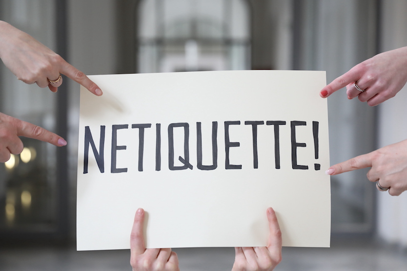 Symbolbild Netiquette, ein Bild auf dem "Netiquette" steht und ein paar Hände zeigen auf das Wort