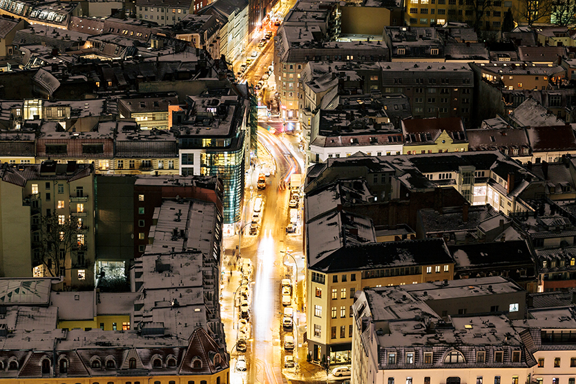 Luftaufnahme eines Stadteils mit beleuchteten Straßen zum Thema Versorgungssicherheit