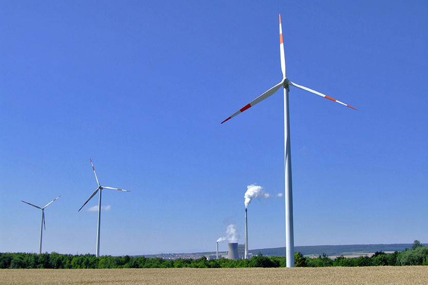 Windräder stehen vor Braunkohlekraftwerk, symbolisiert Kapazitätsreserve