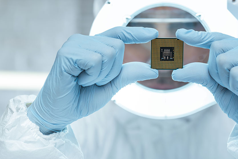 Forscher mit einem Mikrochip in der Hand, symbolisiert das Thema Zukunftsfeld Mikroelektronik