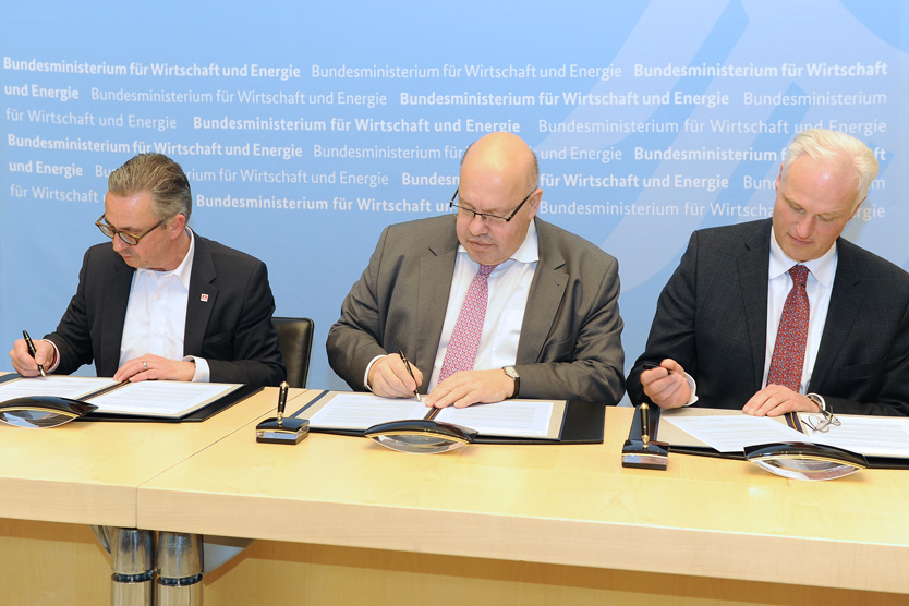Bundesminister Altmaier (Mitte), der Präsident des Verbandes Deutscher Maschinen- und Anlagenbau e.V. (VDMA), Carl-Martin Welcker, und das Geschäftsführende Vorstandsmitglied der IG Metall, Wolfgang Lemb, unterzeichnen die Gemeinsame Erklärung