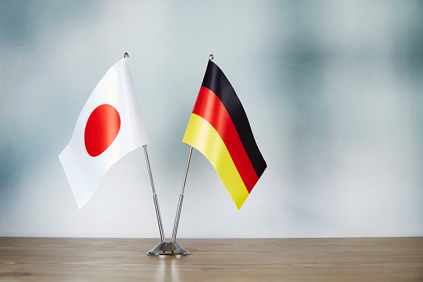 Eine japanische und deutsche Flagge stehen auf dem Tisch