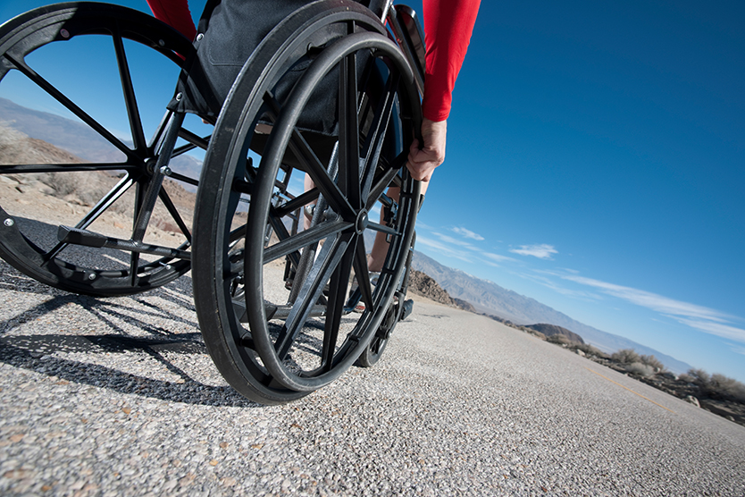 Rollstuhlfahrer fährt auf der Straße symbolisiert Barrierefreiheit