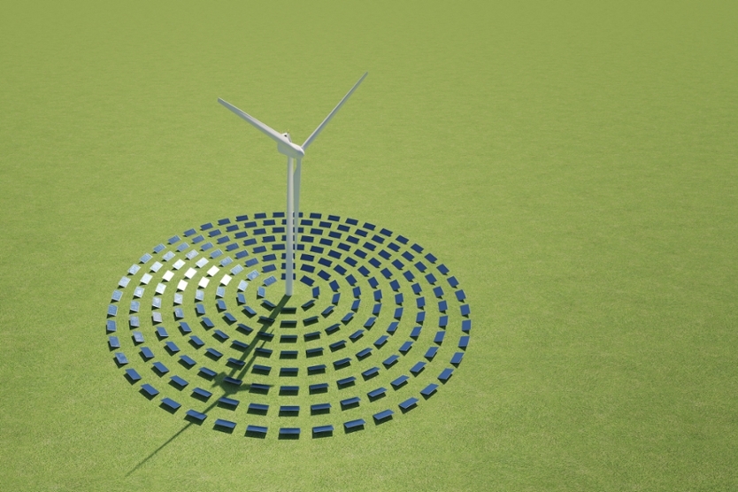 Windrad umringt von Solarpanelen auf grünem Grund
