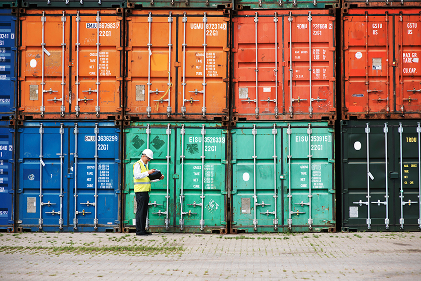 Worker in front of containers symbolizes Promotion of foreign trade and investment; Source: Getty Images/Yur_Arcurs