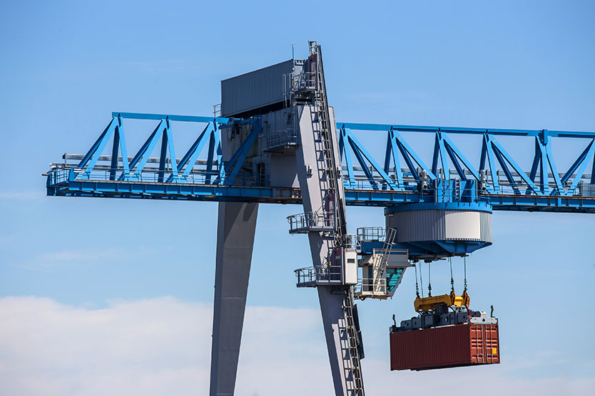 Port crane handling a container, symbolising defence exports