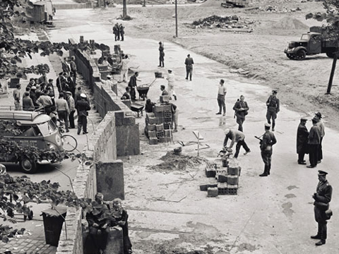 Le 13 août 1961, la RDA, soutenue par le Pacte de Varsovie, débute la construction d'un mur le long des secteurs occidentaux de Berlin. Les échanges de biens et de services sont par conséquent interrompus  ; Source: Bundesbildstelle